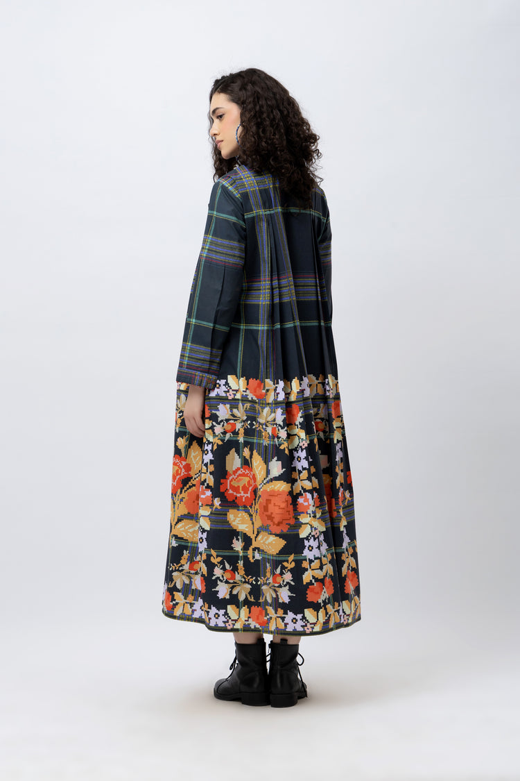 Woman wearing a plaid coat over a floral dress on a white background